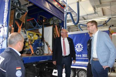 Zugführer Ingo Sauer (links) erläutert Kurt Wiegel und Michael Ruhl die Beladung der THW-Lkw 